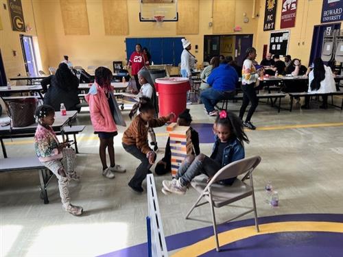  six children playing giant Jenga on the floor